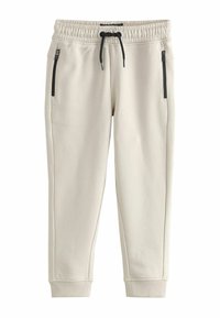 Beige sweatpants with an elastic waistband, drawstring closure, and two zippered side pockets; ribbed cuffs at the ankles.