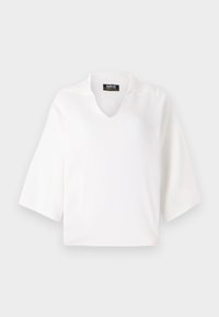 Bílý pletený top s krátkým rukávem, V-výstřihem a mírně strukturovaným límcem. Hladká textura, boxový tvar a minimalistický design.