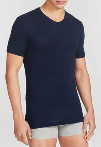 T-shirt a maniche corte blu navy con scollo a V, realizzato in tessuto morbido, design aderente, texture liscia e cuciture minime per il comfort.