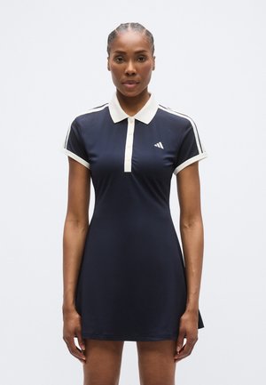 Robe polo bleu marine à manches courtes, col blanc et patte de boutonnage à trois boutons. Caractérisée par des rayures blanches sur les épaules et un logo sur la poitrine.