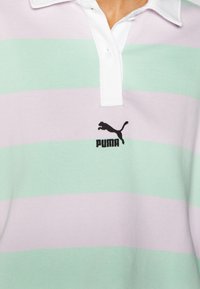 Fénylila és menta zöld vízszintes csíkos póló, fehér gallérral és fekete Puma logóval a mellkason.