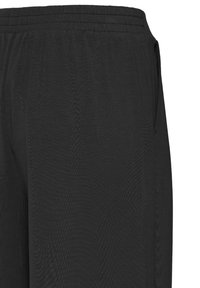 Pantalon de sport noir avec une taille élastique, texture lisse et poches latérales. Le tissu présente un léger éclat.