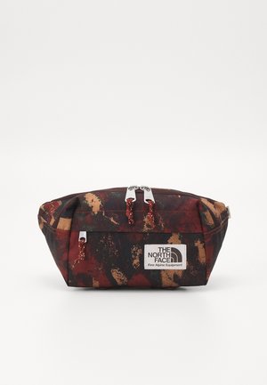 Sac banane rectangulaire compact avec imprimé camouflage rouge, marron et noir, compartiments zippés et patch logo The North Face à l'avant.