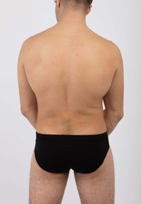 Costume da bagno nero senza cuciture, con vita elastica e design aderente, mostrato da dietro su una persona. Tono della pelle chiaro visibile.