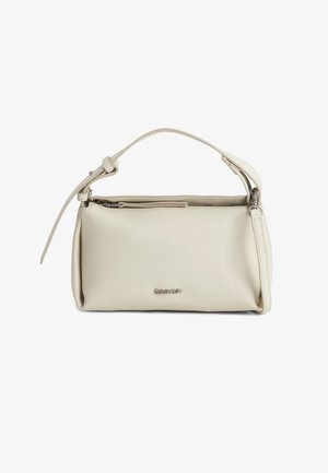 Crèmekleurige handtas van imitatieleer met een gebogen structuur, een bovenste ritssluiting, een kort verstelbaar handvat en een subtiel merklogo aan de voorkant.