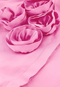 Roze stof met vijf gelaagde stoffen rozen met een gladde textuur, weergegeven tegen een effen roze achtergrond.