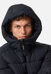 Czarna pikowana kurtka z dużym, wyściełanym kapturem i przednim zamkiem błyskawicznym. Tkanina ma gładką teksturę z puchatymi sekcjami.