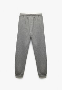 Grå sweatpants lavet af tekstureret stof, med elastisk talje og tapered manchetter ved anklerne. Enkel, funktionel design.