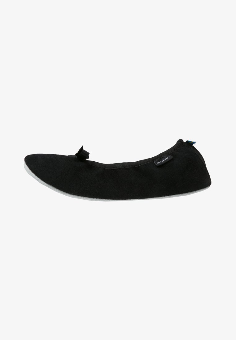Chinelo preto com parte superior em camurça macia, bico arredondado, sola cinza plana e detalhe de laço decorativo na frente; design minimalista.