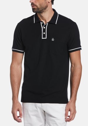 Schwarzes Poloshirt mit weißen Akzenten, ausgestattet mit einer Knopfleiste mit zwei Knöpfen, kurzen Ärmeln und einer Brusttasche, die mit einem Pinguin-Logo bestickt ist.