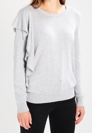 Pull long à manches longues gris clair avec un col rond, présentant des accents volants sur le côté gauche et des poignets et un ourlet côtelés. Texture lisse.