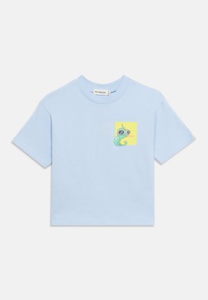 Svetlo modra majica s kratkimi rokavi z majhno grafiko zelene kameleona z sončnimi očali na rumenem kvadratu na prsih.