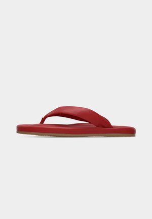 Rød klip-klap sandal med polstret rem mellem tæerne og flad sål på en lysegrå baggrund.
