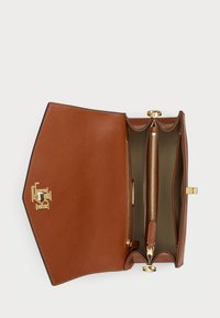 Brun läderhandväska med en strukturerad form, guldfärgade metalldetaljer och ett fack med dragkedja inuti. Interiören har en rymlig design.