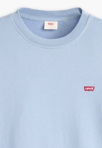 Camiseta de cuello redondo en azul claro, hecha de algodón suave, con cuello acanalado y un pequeño logo rojo de Levi's en el lado izquierdo del pecho.
