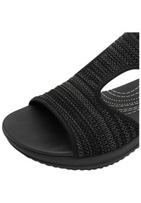 Infradito neri con tomaia tessuta testurizzata, design open toe e suola nera solida imbottita con un motivo a onda.