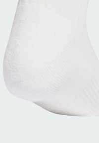 Calzino bianco in cotone con texture a coste, finitura liscia e forma sagomata intorno al tallone, progettato per comfort e aderenza.