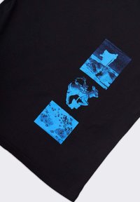 T-shirt in cotone nero con stampe grafiche blu di animali e texture in forme rettangolari. Tessuto morbido, maniche corte, design con colletto rotondo.