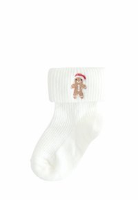 Weiße, gerippte Socke mit einem gestickten Lebkuchenmann mit rotem Hut am Bund. Weicher Stoff, knöchellanges Design.