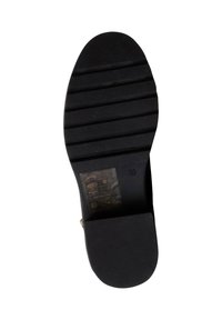 Semelle de chaussure en caoutchouc noir avec un motif de texture antidérapant, un orteil arrondi et une étiquette de taille estampillée avec des instructions d'entretien.
