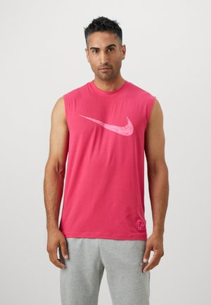 Ärmelloses pinkes Baumwoll-T-Shirt mit einem großen weißen Nike-Swoosh-Logo und einem kleinen Etikett am Saum.