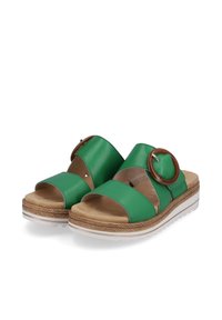 Sandali in pelle verde con due ampie cinghie, dettaglio circolare marrone, soletta beige e suola bianca testurizzata con un design intrecciato.