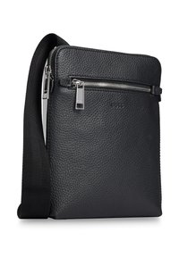 Czarna skórzana torba na ramię z teksturowaną powierzchnią, zamkiem błyskawicznym z przodu i regulowanym paskiem. Posiada błyszczące srebrne akcenty metalowe.