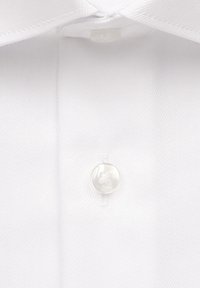 Col haut de chemise blanche avec un tissu lisse et texturé, présentant un seul bouton rond et transparent au niveau du cou.