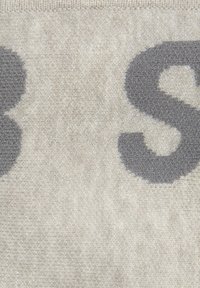 Helles graues Textil mit einer weichen, strukturierten Oberfläche, das große dunkelgraue Buchstaben aufweist. Das Design ist einheitlich ohne sichtbare Muster oder Akzente.