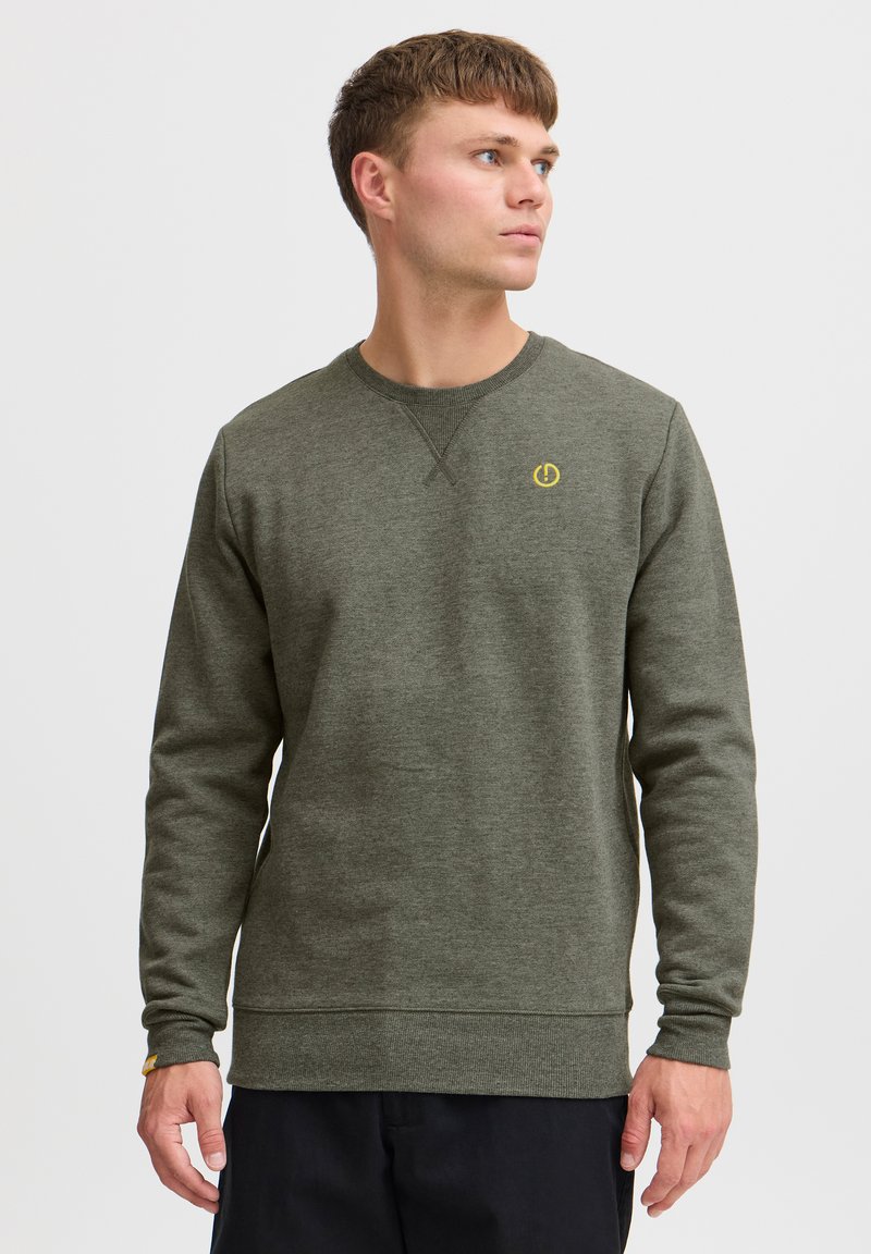 Olive green sweatshirt with long sleeves, ribbed cuffs, a crew neck, and a yellow logo accent on the chest. Made from textured fabric.