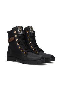 Zwarte leren enkelboots met gouden oogjes, zwarte veters en een gemusterde tong. Heeft een gevarieerd paneel aan de zijkant. Platte zool.