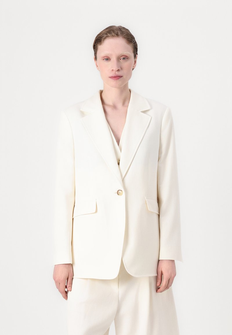 Cremefarbenes maßgeschneidertes Blazer mit Reverskragen, einreihigem Knopfverschluss, zwei Fronttaschen und glatter Textur.