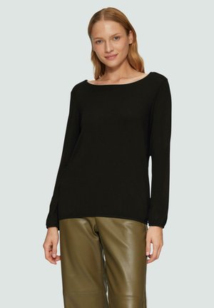 Schwarzes Langarmoberteil mit einem weiten Ausschnitt und gerafften Bündchen, kombiniert mit olivgrünen Lederhosen. Glatte Textur, minimalistisches Design.