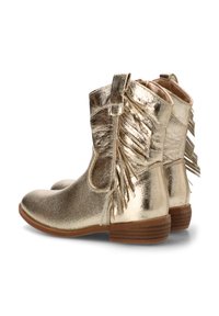 Botines metálicos dorados con una textura suave, detalles de flecos en el lado exterior y un tacón bajo apilado en color marrón. Diseño de punta redondeada.
