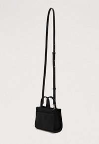Μαύρη μικρή ορθογώνια τσάντα ώμου από ύφασμα με δύο κοντές λαβές και μακρύ ρυθμιζόμενο δερμάτινο λουρί.