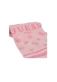 Asciugamano da spiaggia rosa con la parola "GUESS" in lettere grasse, con accenti a motivi e un bordo a righe, realizzato in materiale morbido e assorbente.
