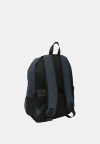 Zaino blu navy e nero con pannelli in rete, spallacci regolabili, maniglia superiore e tasca laterale per riporre oggetti.