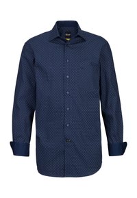 Marineblaues Hemd mit Knöpfen, das ein kleines weißes Punktemuster aufweist, lange Ärmel mit aufgerollten Manschetten und einer Brusttasche auf der linken Seite.
