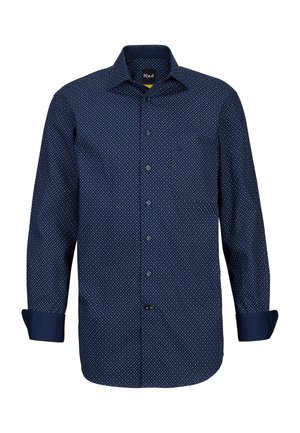 Marineblaues Hemd mit Knöpfen, das ein kleines weißes Punktemuster aufweist, lange Ärmel mit aufgerollten Manschetten und einer Brusttasche auf der linken Seite.