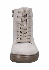 Beige suède enkellaars met een vetersluiting aan de voorkant en een zijrits, voorzien van een getextureerde rubberen zool en een gladde neuskap.