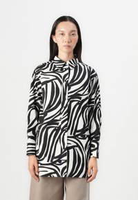 Camicia a maniche lunghe bianca e nera con un motivo a righe vorticoso, colletto e vestibilità rilassata. Tessuto dalla superficie liscia.