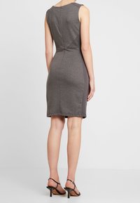 Robe grise sans manches avec une silhouette ajustée, dotée de panneaux latéraux en côtes, d'une texture lisse et d'une fermeture éclair au dos.