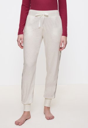 Lichtbeige sweatpants met een trekkoord in de taille, taps toelopende benen en zwarte zijstrepen. Zacht materiaal met geribbelde enkelmanchetten.
