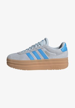 Gray suede sneaker with three blue stripes, rounded toe, and a thick beige sole. Features logo detail on tongue and heel.
