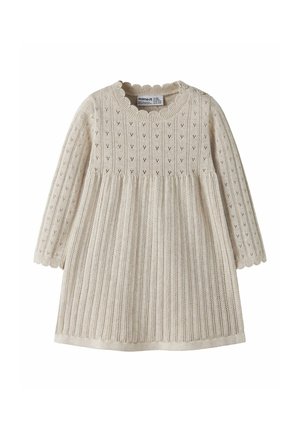Robe de bébé tricotée couleur crème avec manches longues, bords festonnés et petits motifs ajourés sur la partie supérieure et les manches.
