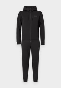 Melnas rāvējslēdzēja sporta tērps no mīksta auduma, ar kapuci, garām piedurknēm un elastīgām aprocēm un apakšmalu. Uz krūtīm ir EA7 logo.