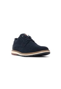 Zapato de ante azul marino con punta redonda, diseño de cordones y suela de color marrón contrastante. Presenta un upper texturizado y detalles en cuero marrón.
