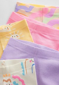 Fyra par leggings i pastellfärger: gula med soltryck, rosa, lavendel och vita med färgglada mönster. Mjuk ribbad textur.