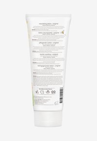 Tube de lotion nourrissante, blanc avec des accents verts. Texte en plusieurs langues sur l'arrière, avec un capuchon à rabat et des ingrédients détaillés.