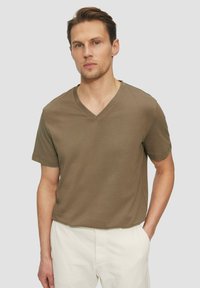 Oliwkowa koszulka V-neck wykonana z miękkiego materiału, z krótkimi rękawami i luźnym krojem, z subtelnym logo na piersi.